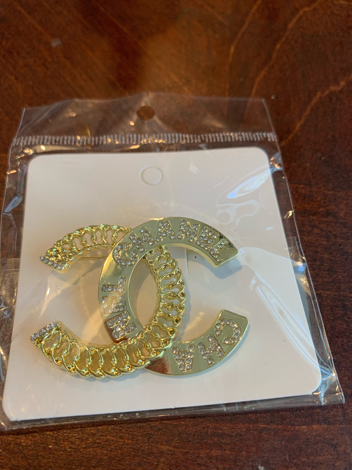 A gold-tone interlocking CC brooch embellished with rhinestones, chanel inspired brooches