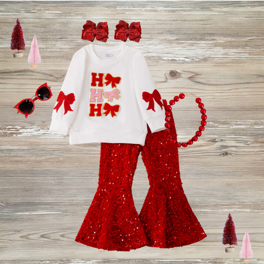 Coquette-style girls' white Christmas top with "Ho Ho Ho" lettering and bows, paired with red sequin bell bottom pants, girls chirstmas red sequin outfit, girls boutique clothing, sequin pants christmas outfit