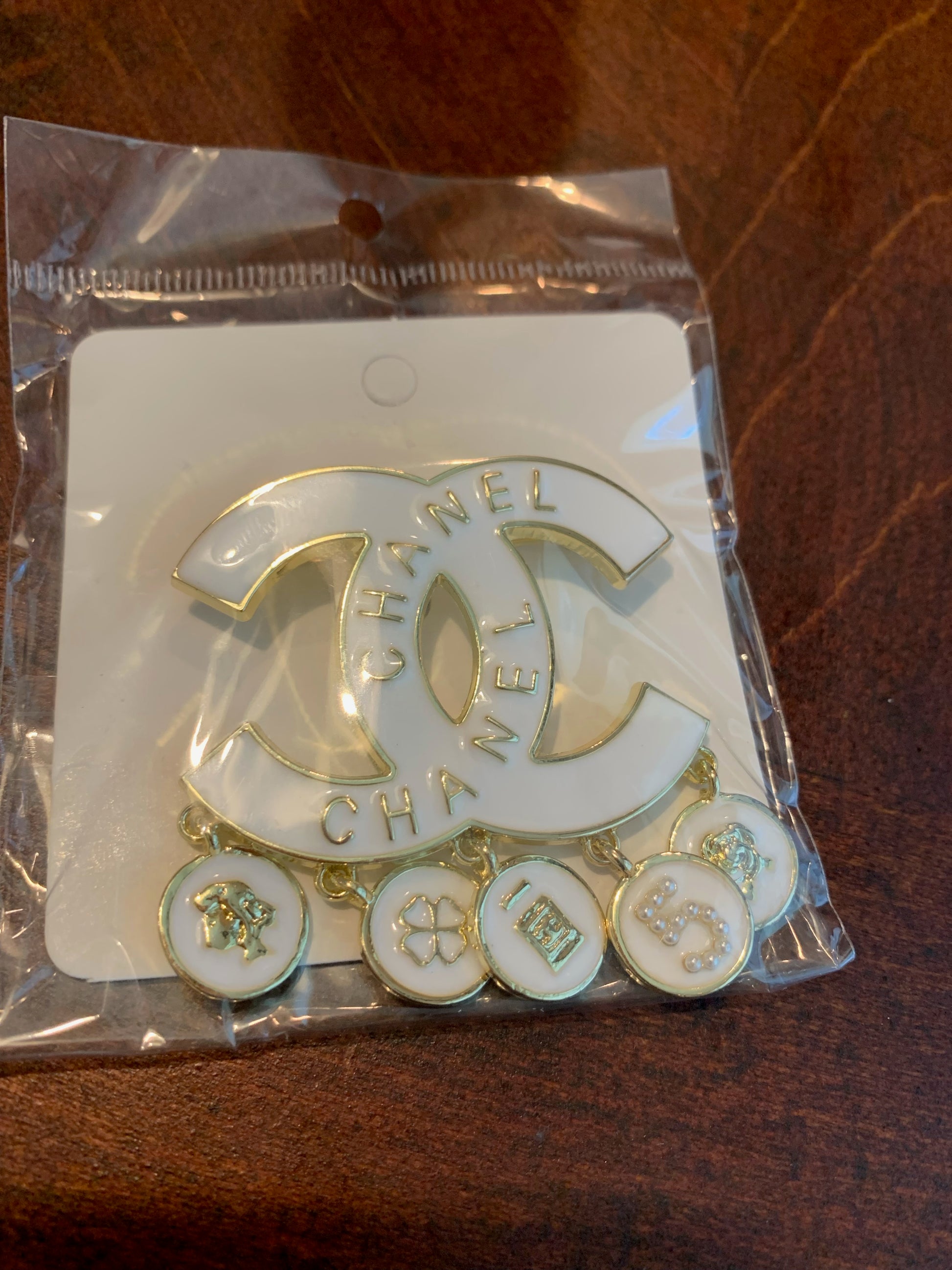 A Chanel logo french charm dangle brooch,  with dangling circular charms, enamel chanel inspired brooch white and gold 