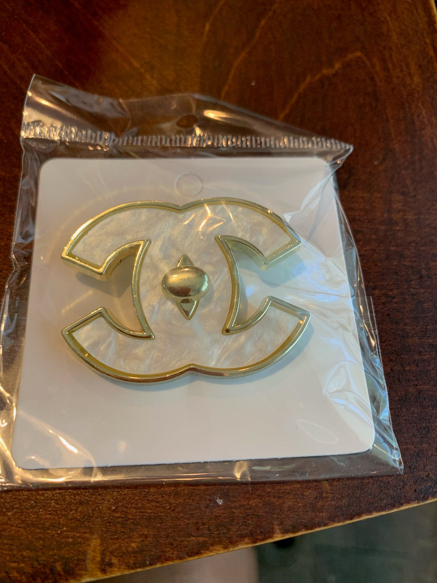 A gold-tone pearl interlocking CC logo charm,  Chanel inspired brooch,  chanel brooches, chanel pearl interlocking brooch