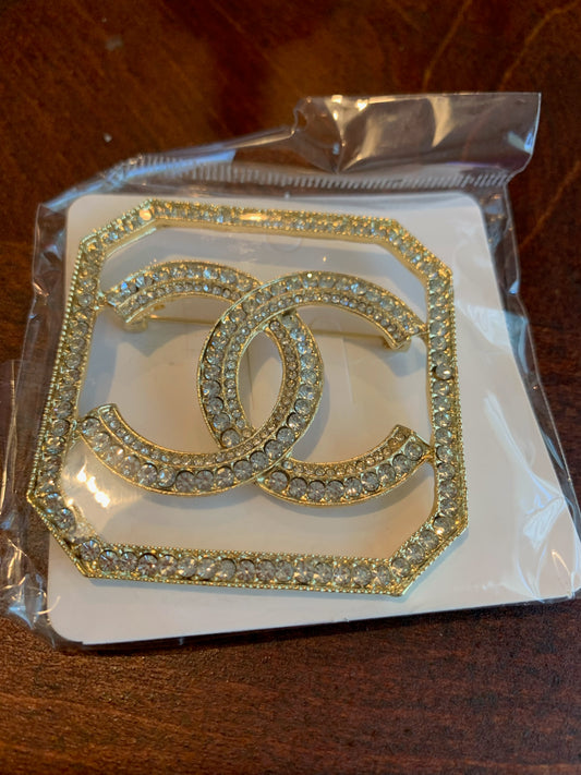 A gold-tone Chanel CC brooch embellished with clear rhinestones, chanel inspired brooches