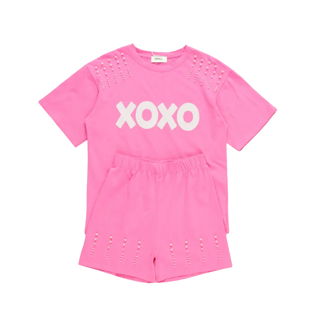 A matching Mommy and Me Valentine's Day outfit set in hot pink. The set features short-sleeve t-shirts with "XOXO" in white text and pearl studs on the shoulders, paired with matching pink shorts with pearl details. online boutique mommy and me outfit, mama and me outfit, mama and mini outfit