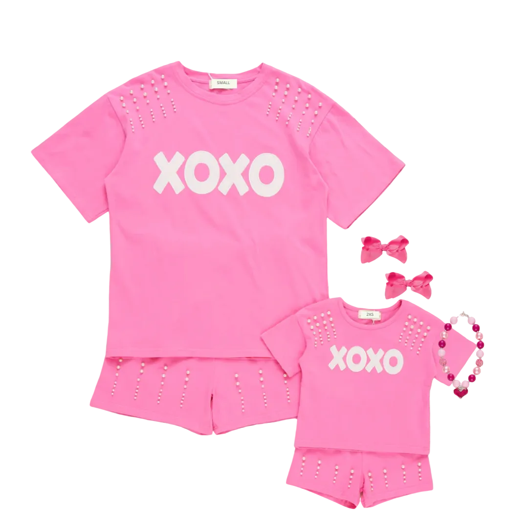 A matching Mommy and Me Valentine's Day outfit set in hot pink. The set features short-sleeve t-shirts with "XOXO" in white text and pearl studs on the shoulders, paired with matching pink shorts with pearl details. online boutique mommy and me outfit, mama and me outfit, mama and mini outfit, mother daughter matching sets outfits, family clothing, galentine's day outfit, Matching Mother Daughter Valentine's Day Outfit"