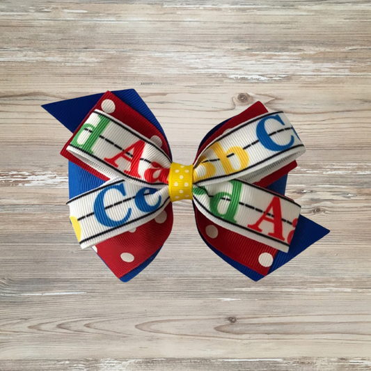 back to school hair bow, ABC hair bow for girls, girls school hair accessory, alphabet bow for toddler, preschool bow, teacher theme bow, kindergarten hair bow, Colorful girls hair bow with layered ribbon featuring A, B, C alphabet letters on handwriting lines, red polka dot ribbon, and yellow center – perfect back-to-school accessory for toddlers and kids